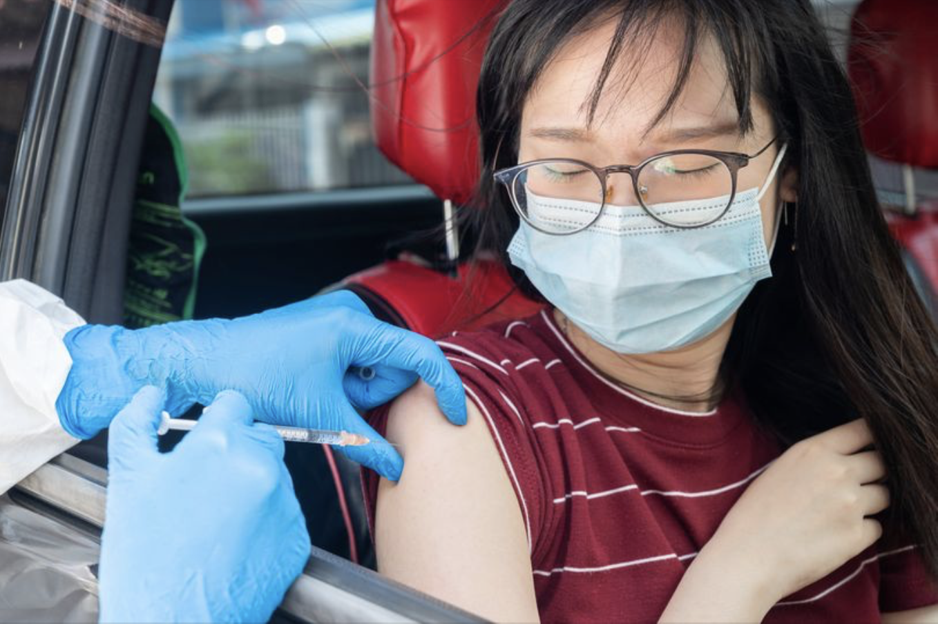 Image of a person getting a flu shot at a drive thru flu clinic 
